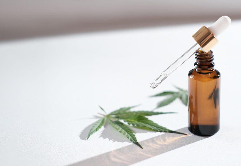 Amber CBD oil bottle beside a laboratory report displaying ALT and AST liver enzyme results
